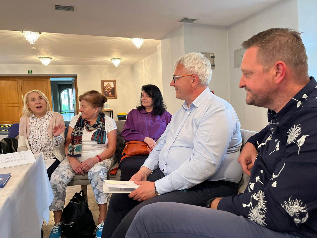 osoby siedzą przy stole